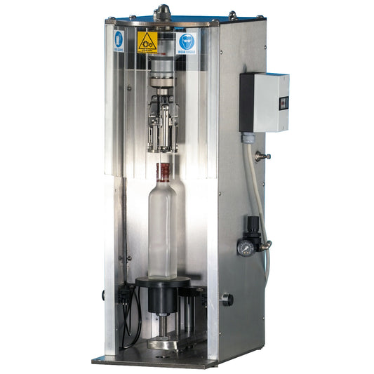 A stainless steel ROPP Tencomax capper machine with a transparent protective cage, a clear bottle mounted in the center, and an attached control box on the side, shown against a plain white background.