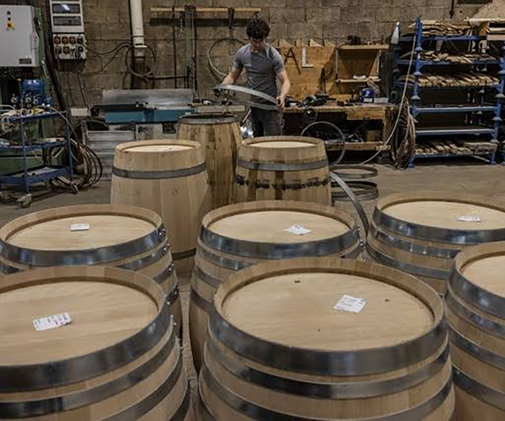 multiple wine barrels in a shed with silver rings
